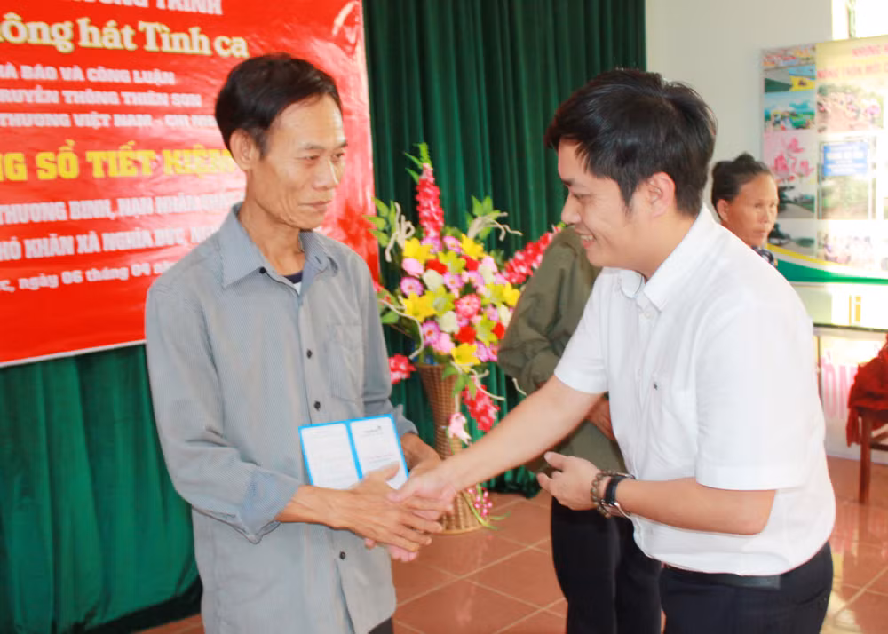 Ông Lê Trần Nguyên Huy - TBT báo Nhà báo & Công luận trao sổ tiết kiệm cho gia đình chính sách.