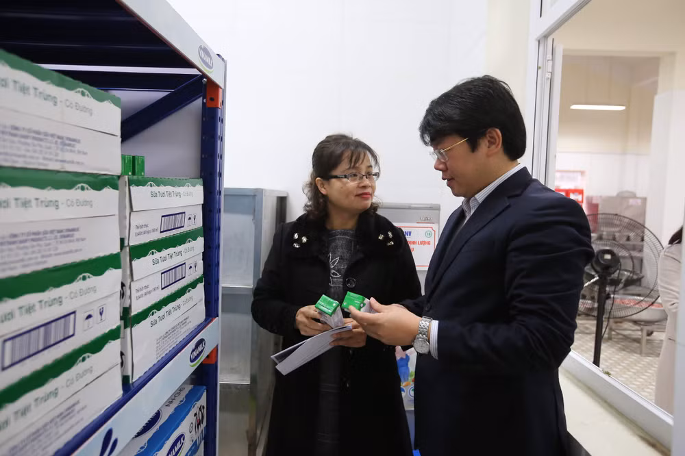 Thầy cô giáo tại một điểm trường tiểu học Hà Nội cẩn thận kiểm tra chất lượng sữa trước giờ xuất sữa cho học sinh tham gia chương trình uống sữa học đường