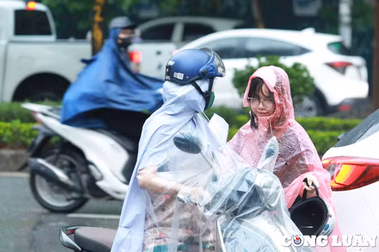 Phụ huynh "đội mưa" đưa con đi thi môn cuối của kỳ thi lớp 10 công lập Hà Nội