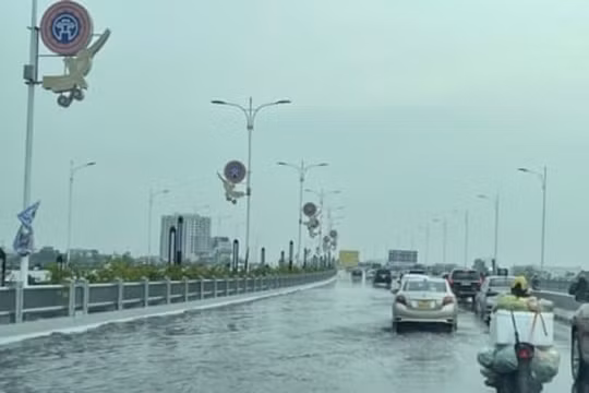 Mặt cầu Vĩnh Tuy đọng nước do lỗ thoát bị bịt kín bởi rác thải