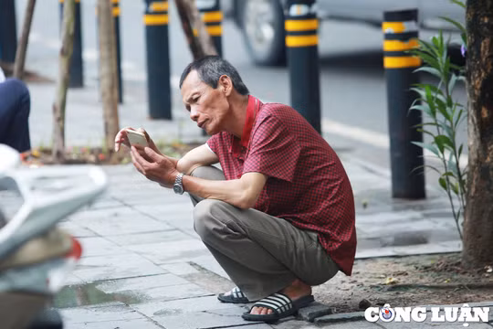 Phụ huynh ngồi xổm "thấp thỏm" ngóng con thi môn đầu tiên của kỳ thi THPT 2024