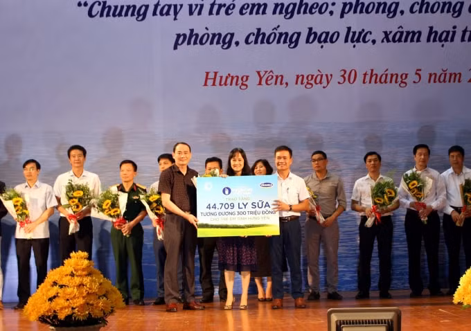 Bà Nguyễn Thị Minh Tâm, Giám đốc Chi nhánh Vinamilk Hà Nội đại diện công ty trao bảng tượng trưng 44.709 ly sữa cho đại diện tỉnh Hưng Yên