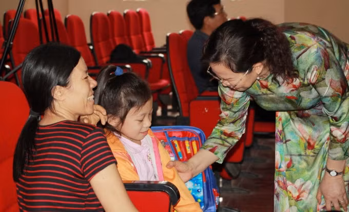 Bà Lê Thị Thủy động viên, hỏi thăm em Đặng Thị Thảo Linh bị mắc bệnh xương thủy tinh tại huyện Kim Thành.