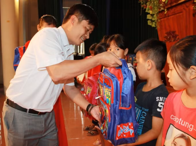 Ông Lê Trần Nguyên Huy - TBT báo Nhà báo và Công luận trao quà cho các em học sinh có hoàn cảnh khó khăn.