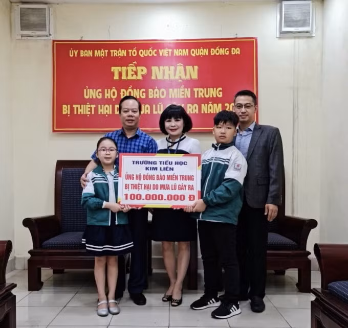 Đại diện trường Tiểu học Kim Liên và em Ngô Chúc An (bên trái) ủng hộ đến đồng báo miền Trung. Ảnh: Dương Lâm