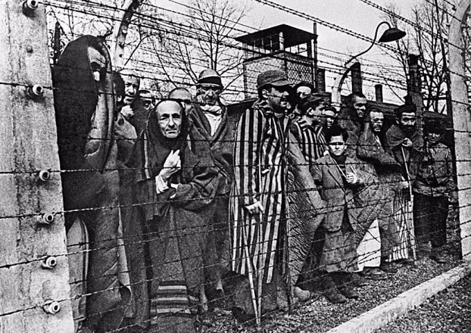 Các tù nhân của trại tử thần Auschwitz chụp ảnh qua dây thép gai. Ảnh: SPUTNIK / B. BORISOV