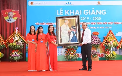 Phó Thủ tướng Thường trực tặng bức tranh Bác Hồ với thiếu nhi cho nhà trường. Ảnh: VGP