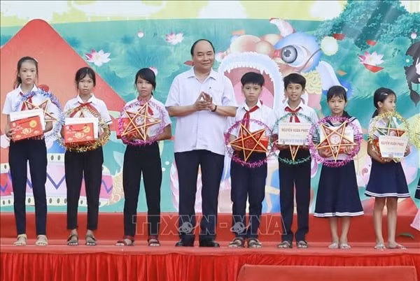 Thủ tướng Nguyễn Xuân Phúc tặng quà Tết Trung thu cho thiếu nhi xã Đại Minh, huyện Đại Lộc, tỉnh Quảng Nam. Ảnh: TTXVN
