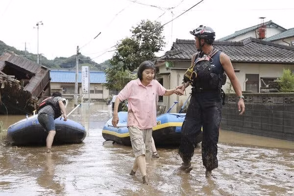 Nhân viên cứu hộ giúp đỡ cư dân ở thành phố Hitoyoshi, thuộc khu vực Kyushu, hôm 4/7. Ảnh: Kyodo.