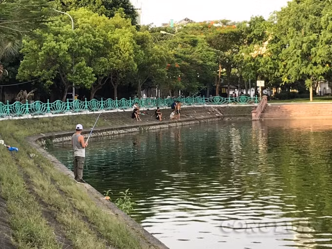 Người dân vô tư đứng ngay sát mép nước để câu cá, hóng mát bất chấp những nguy cơ có thể ngã xuống hồ bất cứ lúc nào