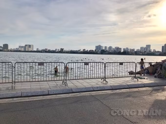Hàng rào chắn ngăn cách trở nên vô tác dụng. Người dân vô tư chơi đùa dưới làn nước mà không hề biết Hồ Tây có những vị trí nông sâu thế nào, nguy hiểm luôn rình rập