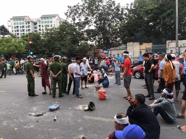 Người thân mang di ảnh ngồi 'ăn vạ' gây tắc đường nghiêm trọng. Ảnh: TL.