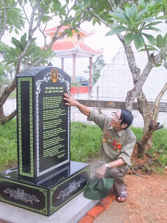 Nhà báo Văn Hiền bên bia đá khắc bài thơ 