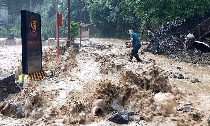 Lực lượng cứu hộ ngăn một đoạn đê vỡ do mưa lũ ở huyện Vu Khê, Trùng Khánh, hôm 12/6. Ảnh: Xinhua