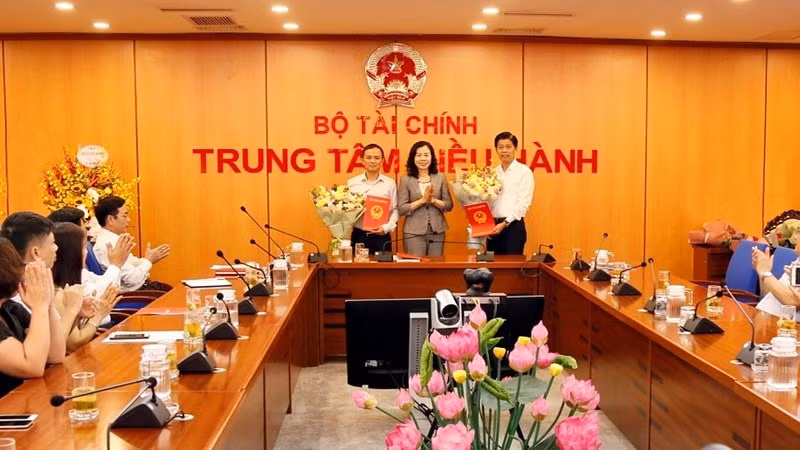 Thứ trưởng Vũ Thị Mai trao quyết định và tặng hoa chúc mừng ông Phạm Văn Hoành (bên phải) và ông Phạm Thu Phong (bên trái). Ảnh: DT
