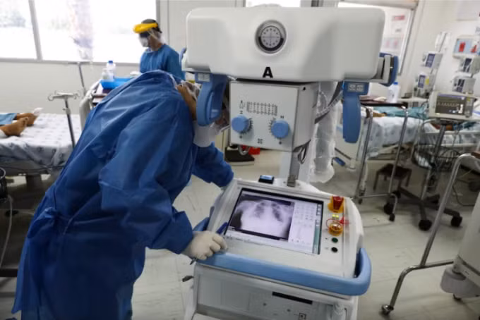 Một nhân viên chăm sóc sức khỏe kiểm tra X-quang ngực của một bệnh nhân trong phòng dành riêng cho bệnh nhân Covid-19 tại Bệnh viện Juarez ở Mexico City. Ảnh: Eduardo Verdugo/AP
