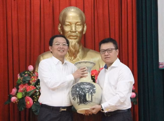 Đồng chí Lê Quốc Minh, Ủy viên Trung ương Đảng, Tổng Biên tập Báo Nhân Dân, Phó Trưởng ban Tuyên giáo Trung ương, Chủ tịch Hội Nhà báo Việt Nam trao quà lưu niệm cho Bí thư Tỉnh ủy Hồ Quốc Dũng. Ảnh: N.V.T