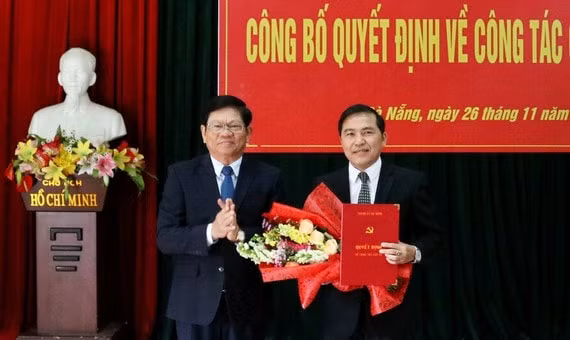 Ông Võ Công Trí, Phó Bí thư Thường trực Thành ủy Đà Nẵng trao quyết định và tặng hoa chúc mừng nhà báo Nguyễn Đức Nam. Ảnh: sggp.org.vn