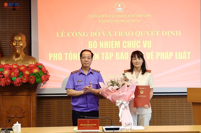 Đồng chí Trần Hải Quân, Phó Viện trưởng VKSND tối cao trao quyết định và tặng hoa chúc mừng đồng chí Hồ Thị Kim Thoan được bổ nhiệm giữ chức vụ Phó Tổng Biên tập Báo BVPL.