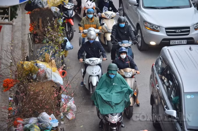 Vào sáng nay, thời tiết tại Hà Nội có mưa nhỏ nên một số người dân mặc áo mưa trong lúc di chuyển ngoài đường