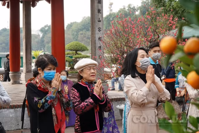 Tuy nhiên bên cạnh đó vẫn còn một số người bỏ khẩu trang ra để chụp ảnh hoặc kéo khẩu trang xuống dưới cằm để lễ,…