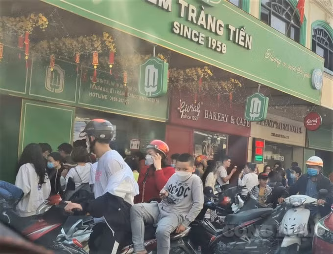 Mùng 3 Tết, tại điểm bán kem Tràng Tiền (Phố Tràng Tiền, Hà Nội), người dân vô tư tụ tập đông người, ăn kem. Ảnh:KN