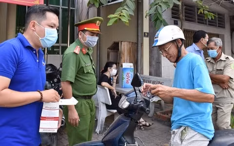 Cảnh sát phát khẩu trang, yêu cầu người dân thực hiện nghiêm các biện pháp phòng dịch Covid-19. Ảnh: Zingnews.vn