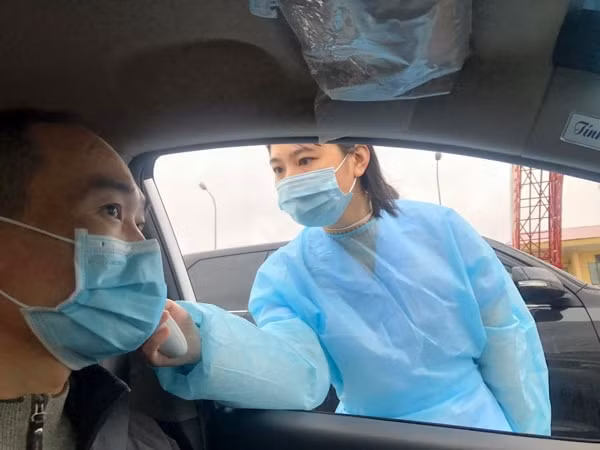 Người dân khi đến chốt kiểm dịch qua cầu Tân Đệ được đo thân nhiệt phòng chống dịch bệnh COVID-19 trước khi vào tỉnh Thái Bình.