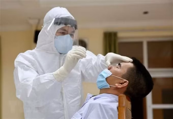 Nhân viên y tế lấy mẫu diện rộng để xét nghiệm Covid-19. Ảnh: HCDC