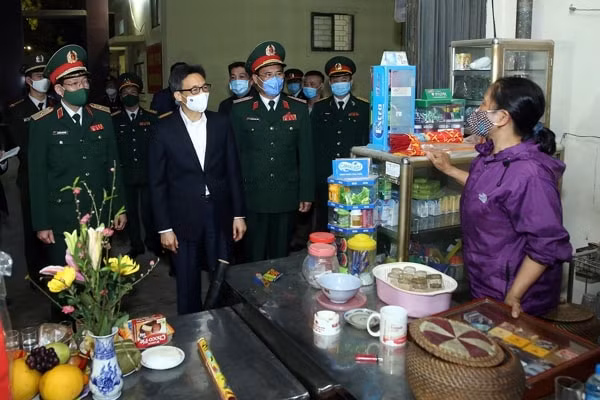 Phó Thủ tướng Vũ Đức Đam thăm hỏi và chúc Tết người dân sinh sống ở gần khu cách ly. Ảnh: VGP