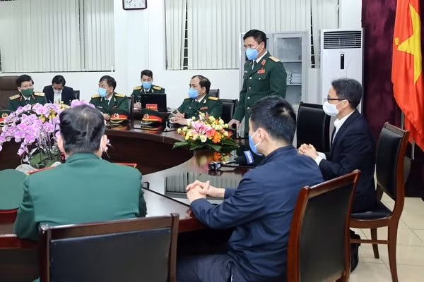 Phó Thủ tướng Vũ Đức Đam nghe Tư lệnh Binh đoàn 11 báo cáo về tình hình cách ly tại Trung tâm Thành An. Ảnh: VGP