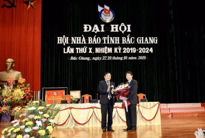 Đồng chí Trịnh Văn Ánh, Chủ tịch Hội Nhà báo tỉnh Bắc Giang khóa X nhiệm kỳ 2014-2019 tặng hoa đồng chí Nguyễn Thế Dũng, nguyên Chủ tịch Hội Nhà báo tỉnh Bắc Giang. Ảnh: Sơn Hải