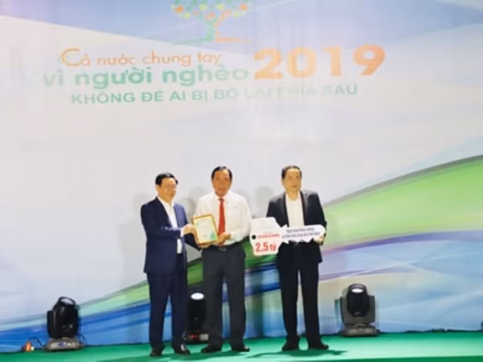 Thành viên HĐTV, Tổng Giám đốc Agribank Tiết Văn Thành (giữa) trao ủng hộ 2,5 tỷ đồng cho hoạt động an sinh xã hội và Quỹ Vì người nghèo và nhận kỷ niệm chương từ Phó Thủ tướng Vương Đình Huệ cho doanh nghiệp có nhiều đóng góp đối với Chương trình.