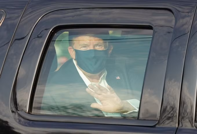 Tổng thống Mỹ Donald Trump vẫy chào người ủng hộ bên ngoài trung tâm y tế Walter Reed. Ảnh: Reuters