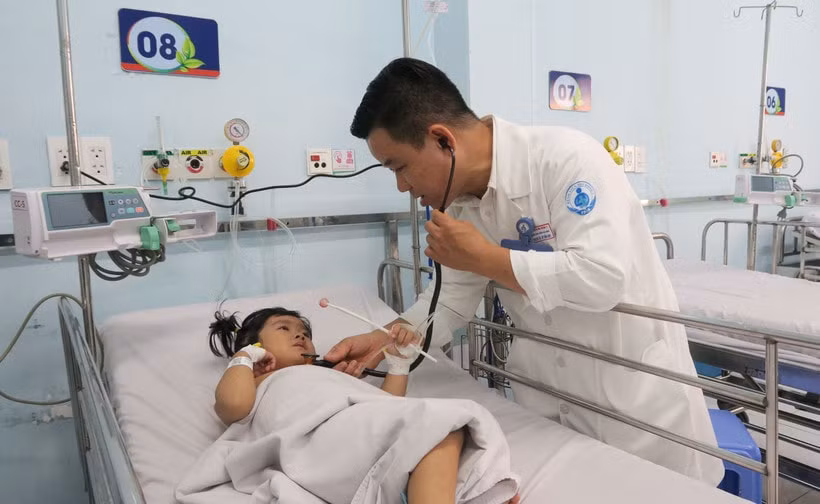 Bác sỹ Bệnh viện Nhi đồng 1 Thành phố Hồ Chí Minh, khám cho bệnh nhi mắc tay chân miệng. (Ảnh: Đinh Hằng/TTXVN)