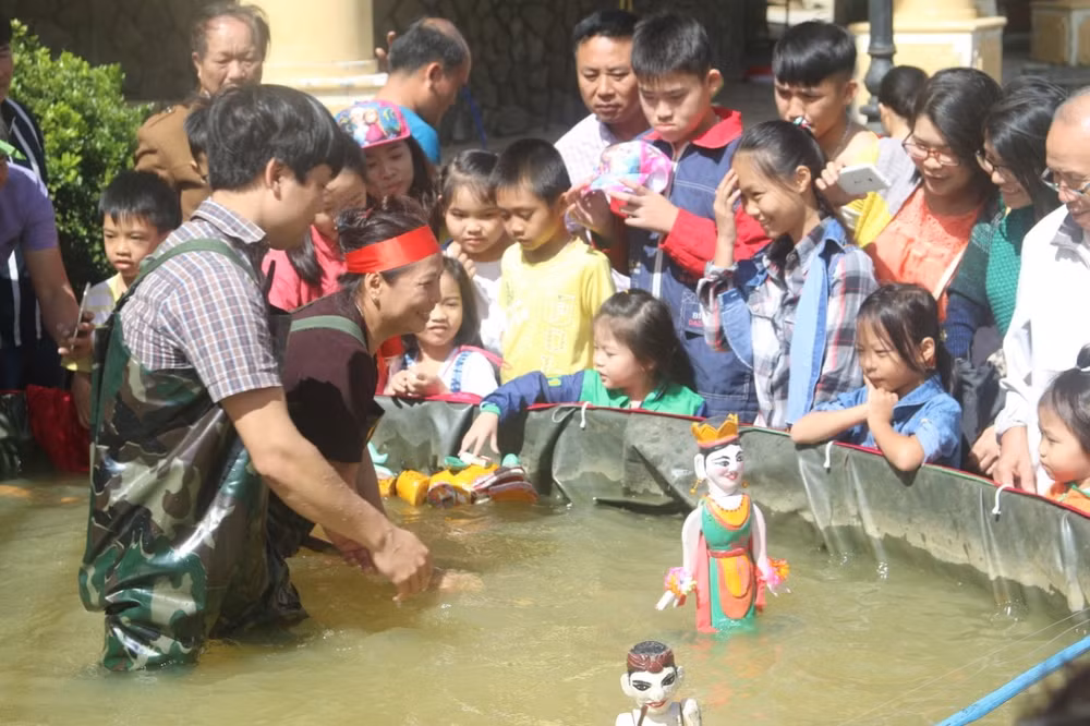 Nghệ nhân Phạm Công Bằng hướng dẫn các em học sinh tìm hiểu nghệ thuật múa rối. Ảnh: NCCC