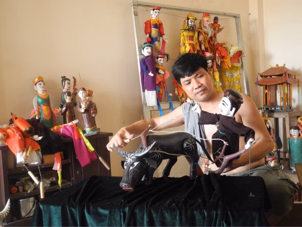 Nghệ nhân Phạm Công Bằng bên những con rối cổ. Ảnh: NCCC