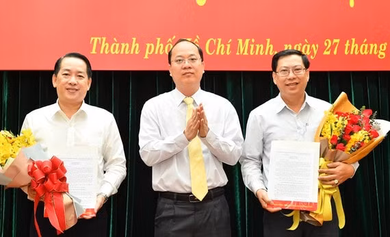 Ông Kiều Ngọc Vũ (trái) và ông Trần Hữu Phước (phải) nhận quyết định điều động từ Phó Bí thư Thành ủy TP HCM Nguyễn Hồ Hải. Ảnh: SGGP