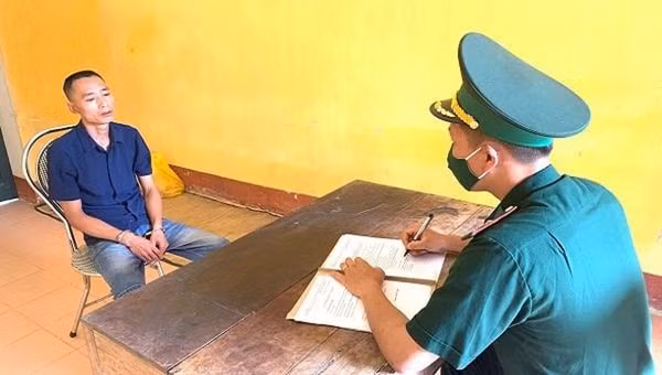 Cán bộ đồn Biên phòng cửa khẩu Trà Lĩnh lấy lời khai đối tượng Lê Quang Quân. Ảnh: PLVN