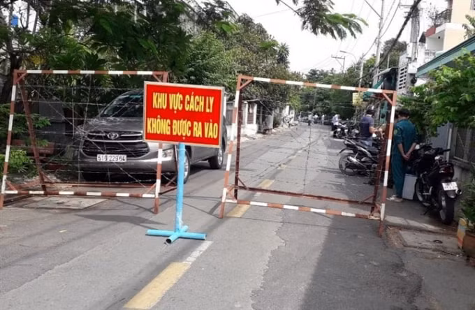 Lực lượng chức năng phong tỏa một đoạn đường TH15 với 16 hộ dân ở huyện Hóc Môn. Ảnh: HCDC