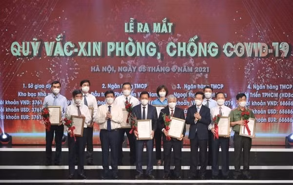 Thường trực Ban Bí thư Võ Văn Thưởng tặng hoa cảm ơn các cơ quan, đơn vị đã ủng hộ Qũy phòng, chống vaccine COVID-19. Ảnh. TPO
