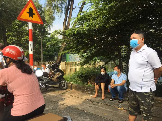 Phụ huynh đứng ngồi trông ngóng thí sinh bên ngoài cổng trường.