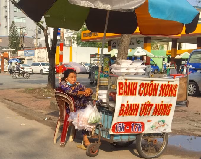 Một người bán hàng đeo như không đeo khẩu trang ờ vỉa hè đường Điện Biên Phủ, phường 15, quận Bình Thạnh, TP. HCM.