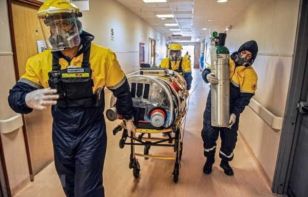 Nhân viên y tế chuyển bệnh nhân COVID-19 tới bệnh viện ở Lima, Peru. Ảnh: AFP