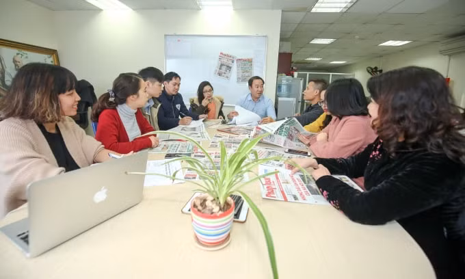 Nhà báo Nguyễn Xuân Khánh (áo xanh) giao ban chuyên môn với Phòng thư kí toà soạn báo Pháp luật & Xã hội.