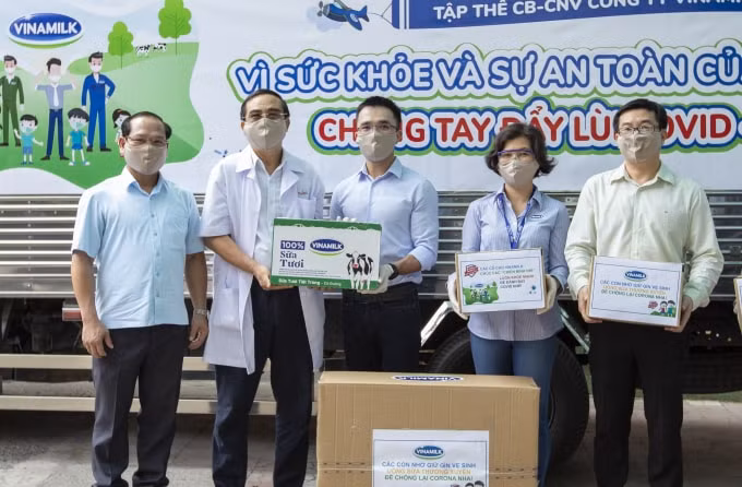 Anh Nguyễn Quang Thái (đứng giữa) đại diện công ty trao tặng sữa cho các trẻ em có hoàn cảnh khó khăn cần giúp đỡ trong dịch Covid-19 vừa qua