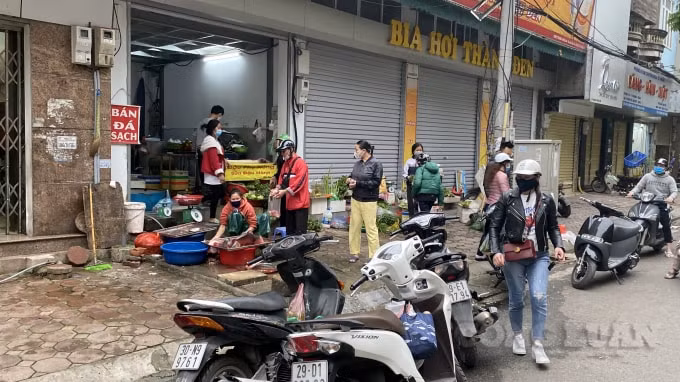 Người dân bỏ cả xe dưới lòng đường để vào đặt mua cá, thịt... ở chợ Đoàn Thị Điểm