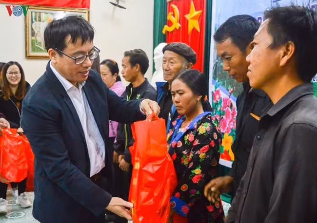 Nhà báo Ngô Thiệu Phong (trái) trao quà từ thiện cho bà con dân tộc Tây Bắc