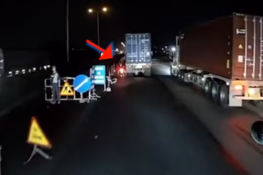 Xe máy đi ẩu may mắn thoát nạn khi luồn lách giữa dàn xe container