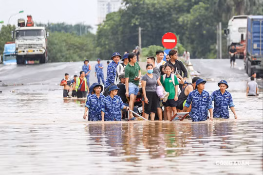 Cảnh sát biển ngâm mình dìu dân vượt qua điểm ngập sâu gần 1m ở Hà Nội